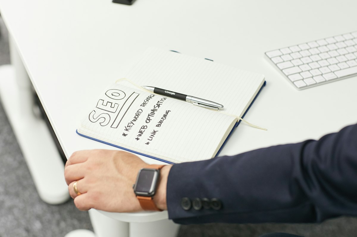 Stratégie de mots-clés SEO notée sur un carnet avec graphiques de performance web