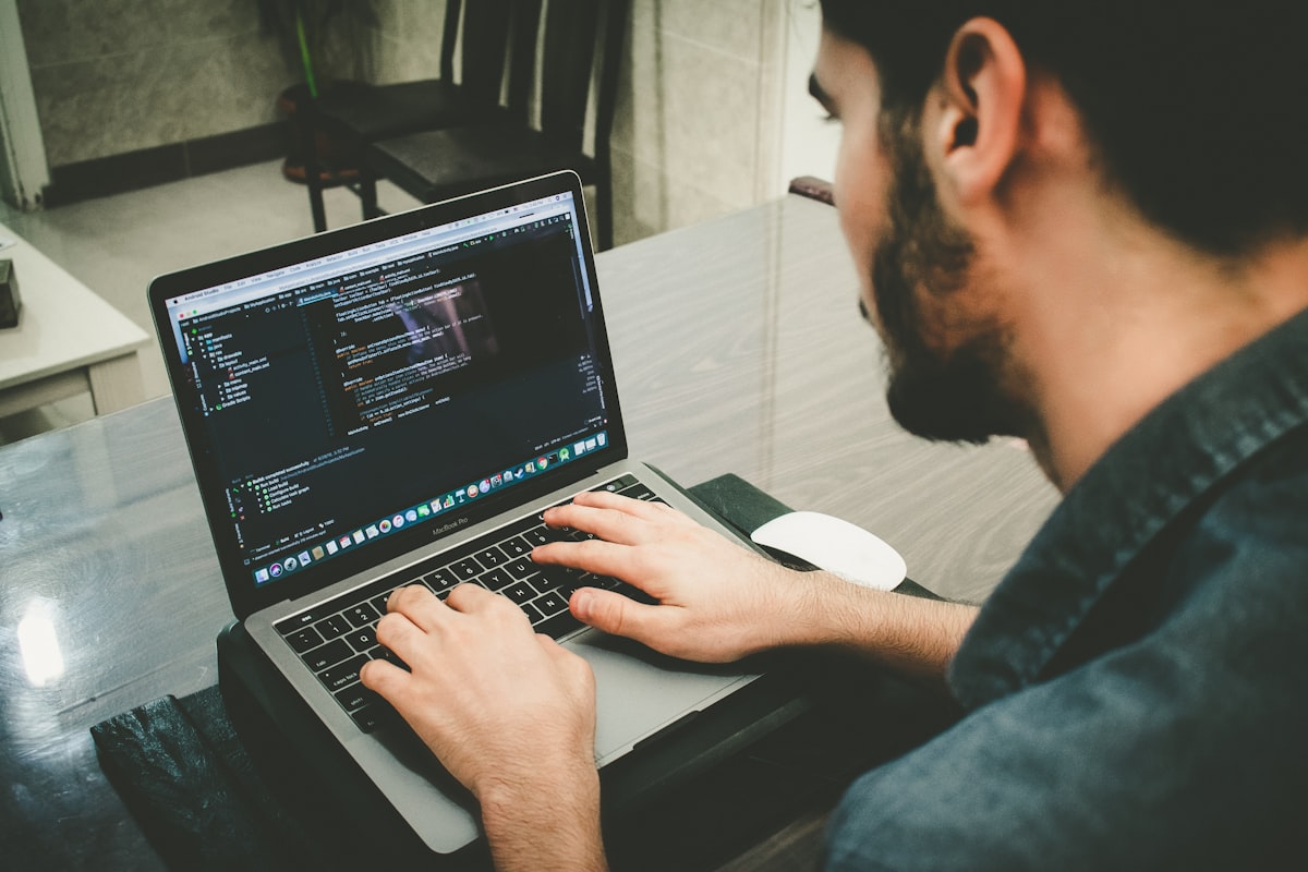 Un entrepreneur TPE calculant le budget annuel de maintenance de son site internet sur une calculatrice
