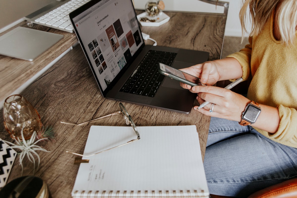 Commerçante gérant sa boutique e-commerce depuis son bureau, entourée de produits à vendre