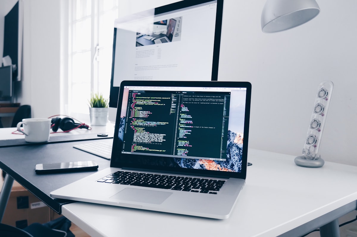 Designer web travaillant sur la mise en page d'un site pour une PME, avec palette de couleurs et maquettes à l'écran