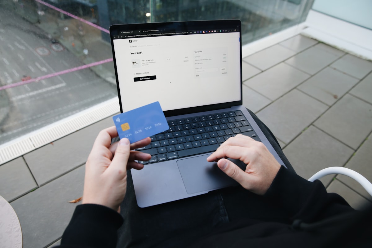 Artisan commerçant consultant les options de paiement en ligne sur son site e-commerce depuis un bureau